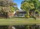 Scenic lake view of backyard showcasing inviting pool, screened porch, and mature landscaping at 1017 American Beauty St, Orlando, FL 32818