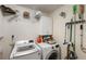 A well-organized laundry room features a modern washer and dryer, plus storage shelving and cleaning supplies at 1017 American Beauty St, Orlando, FL 32818