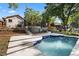Inviting backyard pool with blue trim, surrounded by lush greenery and a screened-in patio area with multiple stairs at 1017 American Beauty St, Orlando, FL 32818
