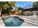 Sparkling pool with cool blue tile and view of backyard, mature trees and distant lake at 1017 American Beauty St, Orlando, FL 32818