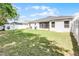 A home's backyard has a grill, a white fence, and green space at 113 St Thomas Dr, Mulberry, FL 33860