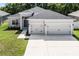 Charming home with a manicured lawn, gray stucco exterior, and a spacious two-car garage at 113 St Thomas Dr, Mulberry, FL 33860