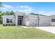 Beautiful home featuring a well-kept lawn, gray stucco, and a convenient two-car garage at 113 St Thomas Dr, Mulberry, FL 33860