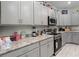 Charming kitchen with modern appliances, gray cabinetry, and light-colored flooring at 113 St Thomas Dr, Mulberry, FL 33860