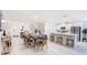 Open-concept dining area showcasing a modern table set, kitchen island, and stainless steel appliances at 114 Tulip Ln, Poinciana, FL 34759