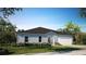 Charming single-story home featuring a two-car garage, well-manicured lawn and tidy landscaping at 114 Tulip Ln, Poinciana, FL 34759