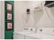 Bright laundry room features side by side washer/dryer, dog themed art and a wire storage shelf at 1218 Alstonia Ln, Mount Dora, FL 32757