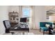 Office features a black desk, stylish blue chair, modern black shelving and natural light from the window at 1218 Alstonia Ln, Mount Dora, FL 32757