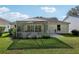 Backyard featuring a screened-in porch and well-maintained lawn at 1309 Carolina Ct, The Villages, FL 32162