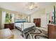Comfortable bedroom with a metal bed frame, ceiling fan, and two side tables with lamps at 1309 Carolina Ct, The Villages, FL 32162