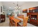 Cozy dining room featuring wood table, chandelier, and sunset artwork on the back wall at 1309 Carolina Ct, The Villages, FL 32162