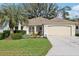 Charming single-story home boasts lush landscaping, well-manicured lawn, and an inviting front entrance at 1309 Carolina Ct, The Villages, FL 32162