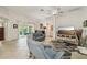 Bright living room with tile floors, ceiling fan, and comfortable blue furniture at 1309 Carolina Ct, The Villages, FL 32162