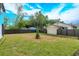 Wide backyard with a fence and a house in the background under a partly cloudy sky at 1340 Crystal Lake E Ave, Orlando, FL 32806