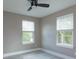 This bedroom features a ceiling fan, neutral paint and hardwood floors with natural light from two windows at 1340 Crystal Lake E Ave, Orlando, FL 32806