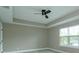 Spacious bedroom featuring tray ceiling, ceiling fan, and window for natural light at 1340 Crystal Lake E Ave, Orlando, FL 32806