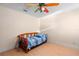 Small bedroom with a blue bedspread, colorful ceiling fan and wood look flooring at 1430 Clarks Summit Ct, Orlando, FL 32828