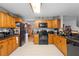 Well-equipped kitchen with wood cabinetry, granite countertops, and black appliances at 1430 Clarks Summit Ct, Orlando, FL 32828