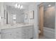 Bright bathroom featuring double sink vanity and shower with tile surround at 16164 Palm Frond Ave, Clermont, FL 34714