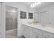 Bright, white bathroom features double vanity, modern fixtures, and glass enclosed shower at 16164 Palm Frond Ave, Clermont, FL 34714