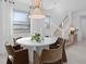 Elegant dining room with a modern table, stylish chairs, and a staircase leading to the upper level at 16164 Palm Frond Ave, Clermont, FL 34714