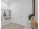 Bright foyer with built-in bench, tile flooring, and modern decor creating a welcoming entrance at 16164 Palm Frond Ave, Clermont, FL 34714