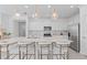 Beautiful kitchen featuring an expansive island with seating, stainless steel appliances, and sleek white cabinetry at 16164 Palm Frond Ave, Clermont, FL 34714