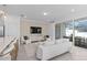 Modern living room with stylish decor, including white furniture, a textured wall, and seamless flow to the kitchen at 16164 Palm Frond Ave, Clermont, FL 34714
