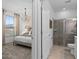 Serene main bedroom featuring a view of bathroom with glass shower and modern window at 16164 Palm Frond Ave, Clermont, FL 34714