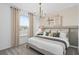 Inviting main bedroom with a large window, plush carpet, and a stylish chandelier at 16164 Palm Frond Ave, Clermont, FL 34714