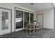 Covered patio area with large sliding glass doors and a dining table provides a relaxing outdoor retreat at 16164 Palm Frond Ave, Clermont, FL 34714
