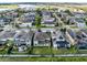 Aerial view of a community with well-maintained homes and a serene lake in the background at 1675 Amsel Falls Park Ter, Winter Garden, FL 34787