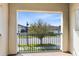 Balcony view featuring a tree, street, and buildings framed by the stucco arch and railing at 1675 Amsel Falls Park Ter, Winter Garden, FL 34787