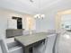 Dining room featuring a gray wood table, white chairs, modern chandelier, and black-and-white artwork at 1675 Amsel Falls Park Ter, Winter Garden, FL 34787