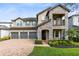 Charming two-story home featuring stone accents, a balcony, a three-car garage, and a well-manicured lawn at 1675 Amsel Falls Park Ter, Winter Garden, FL 34787