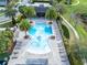 Aerial view of a pristine community pool surrounded by lush greenery and lounge chairs at 1675 Amsel Falls Park Ter, Winter Garden, FL 34787
