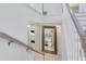Open staircase with white railings and a large framed mirror reflecting the living room at 1675 Amsel Falls Park Ter, Winter Garden, FL 34787