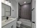Modern bathroom features gray tile, a sleek vanity, and a shower-tub combination at 17167 Sw 40 Ter, Ocala, FL 34473