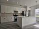 Modern kitchen featuring white cabinets, stainless steel appliances, and a large central island at 17167 Sw 40 Ter, Ocala, FL 34473