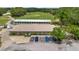 Aerial view of the golf course facility with lush greens and a sheltered driving range, with vehicle parking at 1842 Turnbull Lakes Dr, New Smyrna Beach, FL 32168