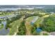 Panoramic aerial view of a sprawling golf course and residential community featuring lakes and mature trees at 1842 Turnbull Lakes Dr, New Smyrna Beach, FL 32168