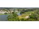 Aerial view of waterfront homes in a golf course community featuring lush greenery and mature trees at 1842 Turnbull Lakes Dr, New Smyrna Beach, FL 32168