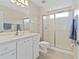 Clean bathroom featuring white vanity, updated lighting, tiled floors, and glass enclosed shower at 1842 Turnbull Lakes Dr, New Smyrna Beach, FL 32168