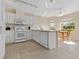 Bright kitchen featuring tile floors, white cabinets, modern appliances, and a cozy breakfast nook with natural light at 1842 Turnbull Lakes Dr, New Smyrna Beach, FL 32168