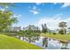 Picturesque pond view surrounded by mature trees, lush landscaping, and green lawn at 1842 Turnbull Lakes Dr, New Smyrna Beach, FL 32168