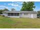 A spacious backyard with a sunroom addition, providing ample space for outdoor activities at 2113 Winnetka Ct, Orlando, FL 32818