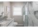 Clean bathroom featuring a glass enclosed marble shower, vanity, and window at 2113 Winnetka Ct, Orlando, FL 32818