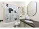 Bright bathroom with tub, Mickey Mouse shower curtain, granite counter and decorative signs at 217 Herring St, Davenport, FL 33897