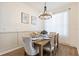 Elegant dining room with a wooden table set for six, stylish chairs, and natural light from the window at 217 Herring St, Davenport, FL 33897