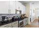 Well-lit kitchen featuring stainless appliances, granite counters, and ample cabinet space at 217 Herring St, Davenport, FL 33897